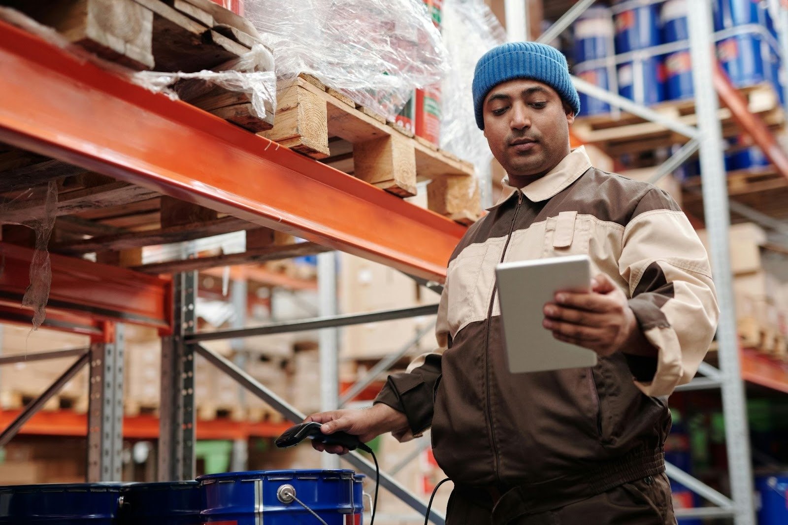 A manufacturing floor worker using a tablet to complete a digital inspection checklist
