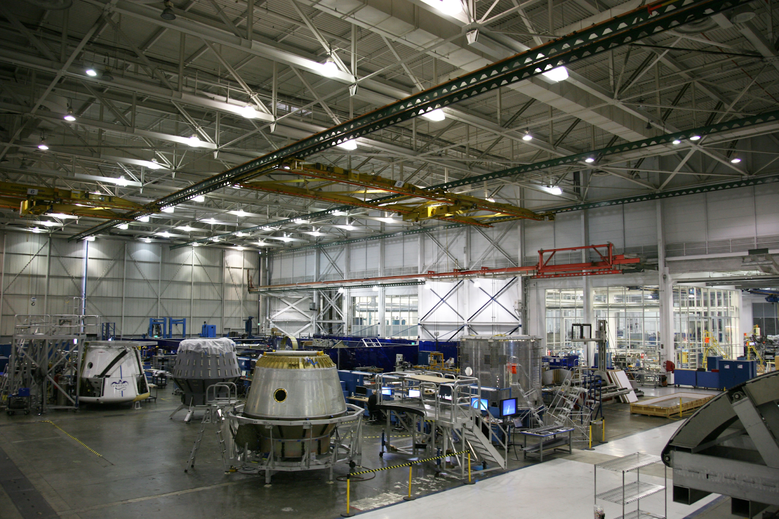 Advanced manufacturing floor featuring large-scale assembly and integrated digital workstations for real-time production monitoring